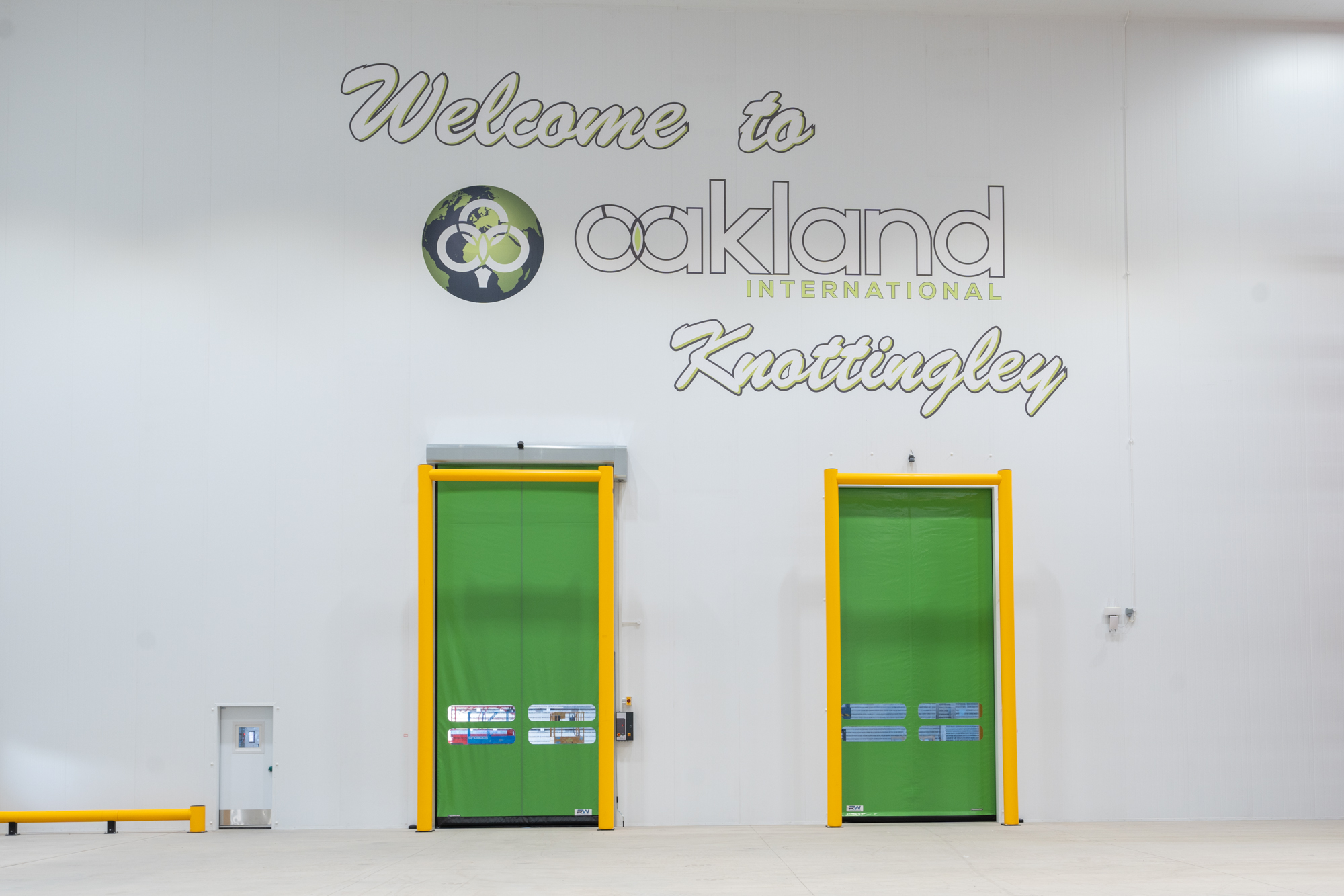 Twin rapid-roll doors with yellow frames in distribution facility